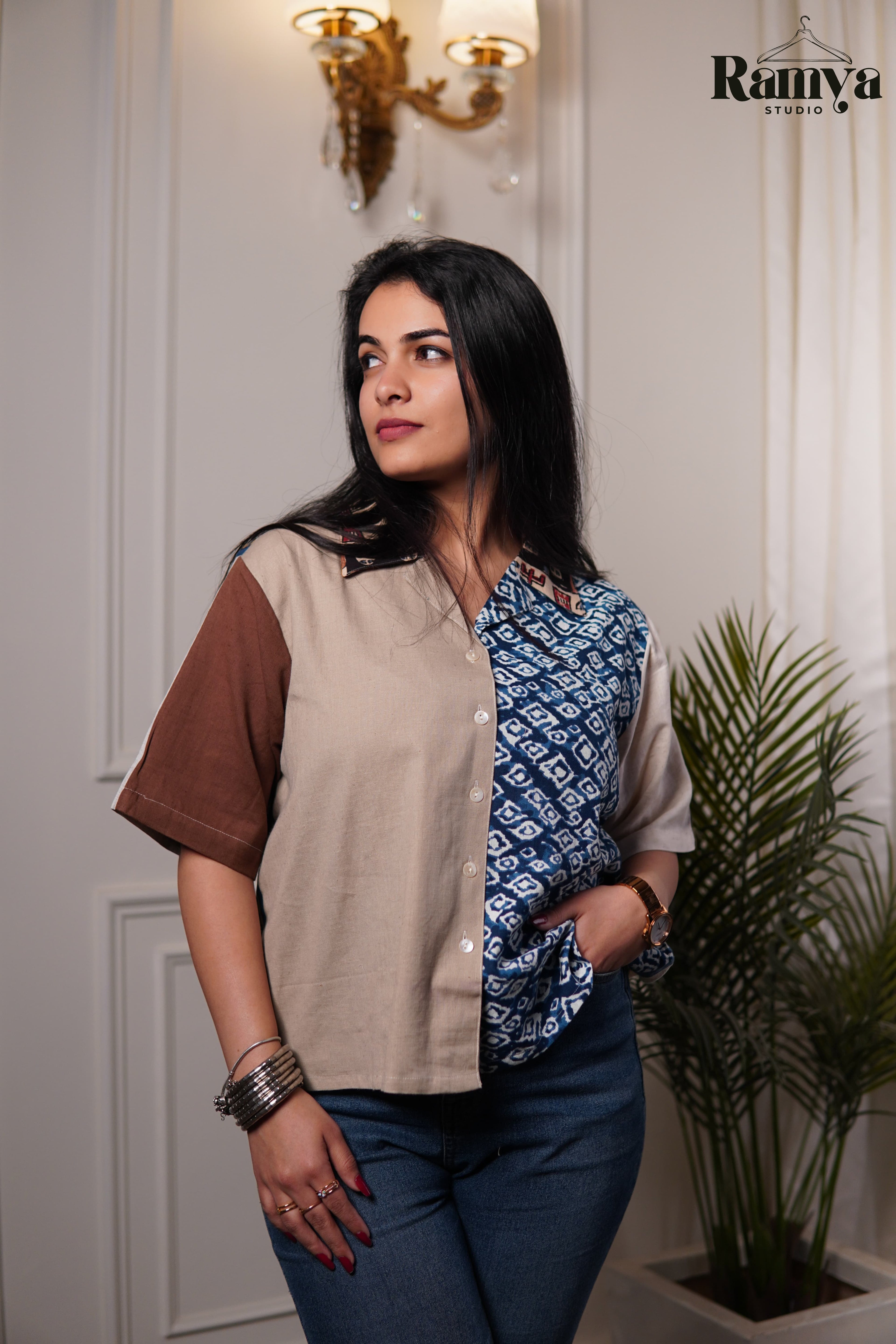 An artisanal cotton shirt top from Ramya Studio showcasing a contrast of earthy neutrals and heritage blue block prints in a modern paneled silhouette.