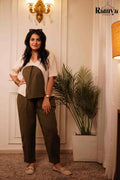 Model posing in an earthy olive green and cream co-ord set, styled with cream loafers and sunglasses
ideal for boutique office wear or a chic brunch look."