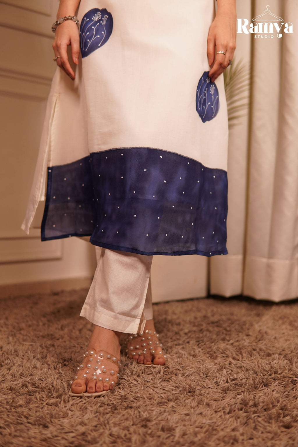 Modern Indian workspace style: A model wearing an off-white and ink-blue straight-cut kurta set with transparent block heel sandals