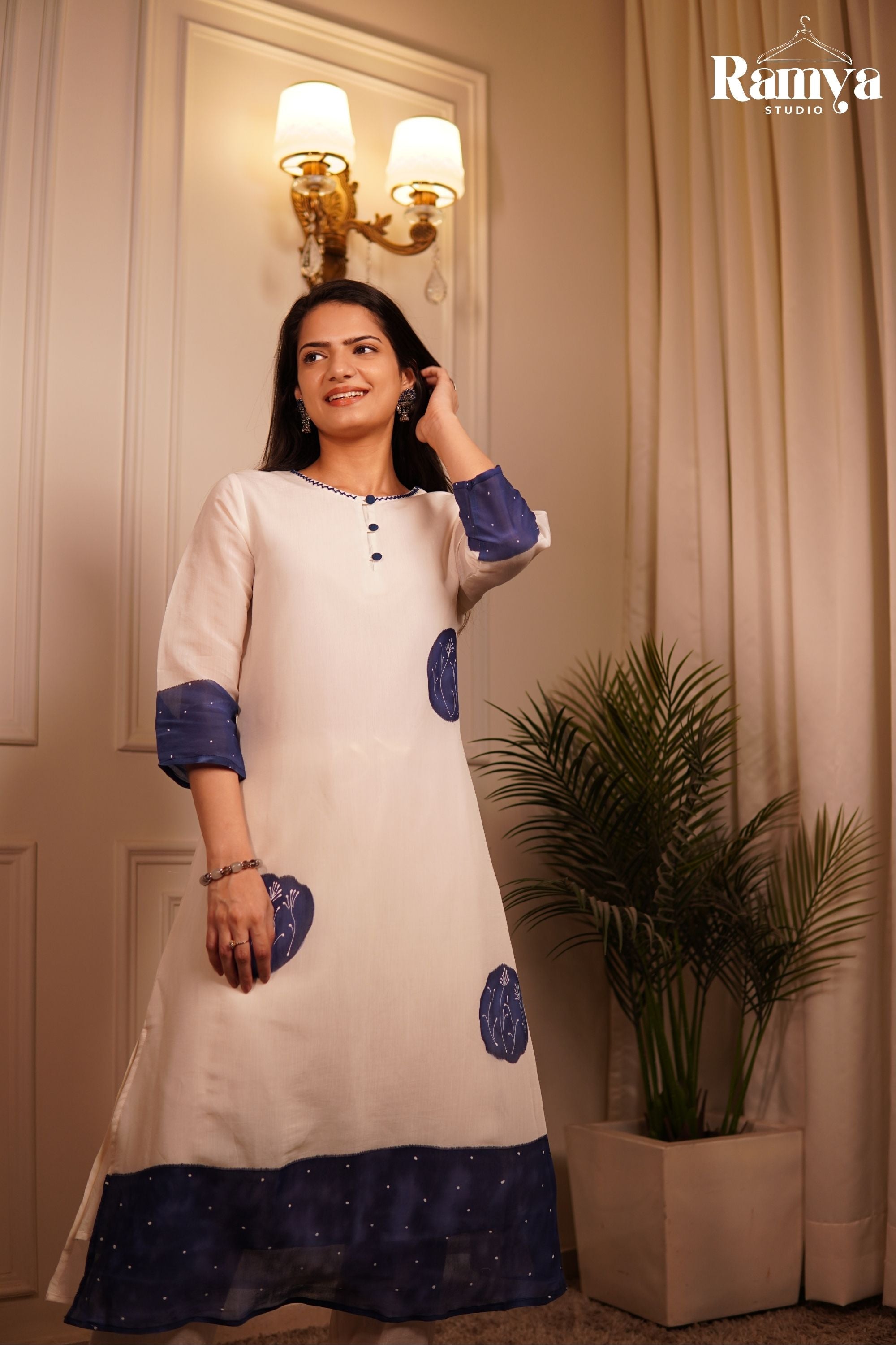 Full-length image of a women's 2-piece ethnic suit in off-white cotton blend with contrasting indigo tie-dye style borders and straight trousers.