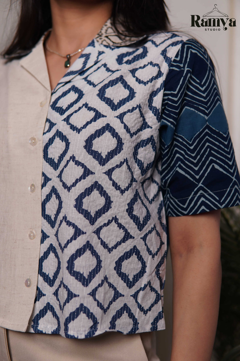 An artisanal paneled shirt top from Ramya Studio, combining earthy stone neutrals with heritage indigo block prints in a structured, modern silhouette.