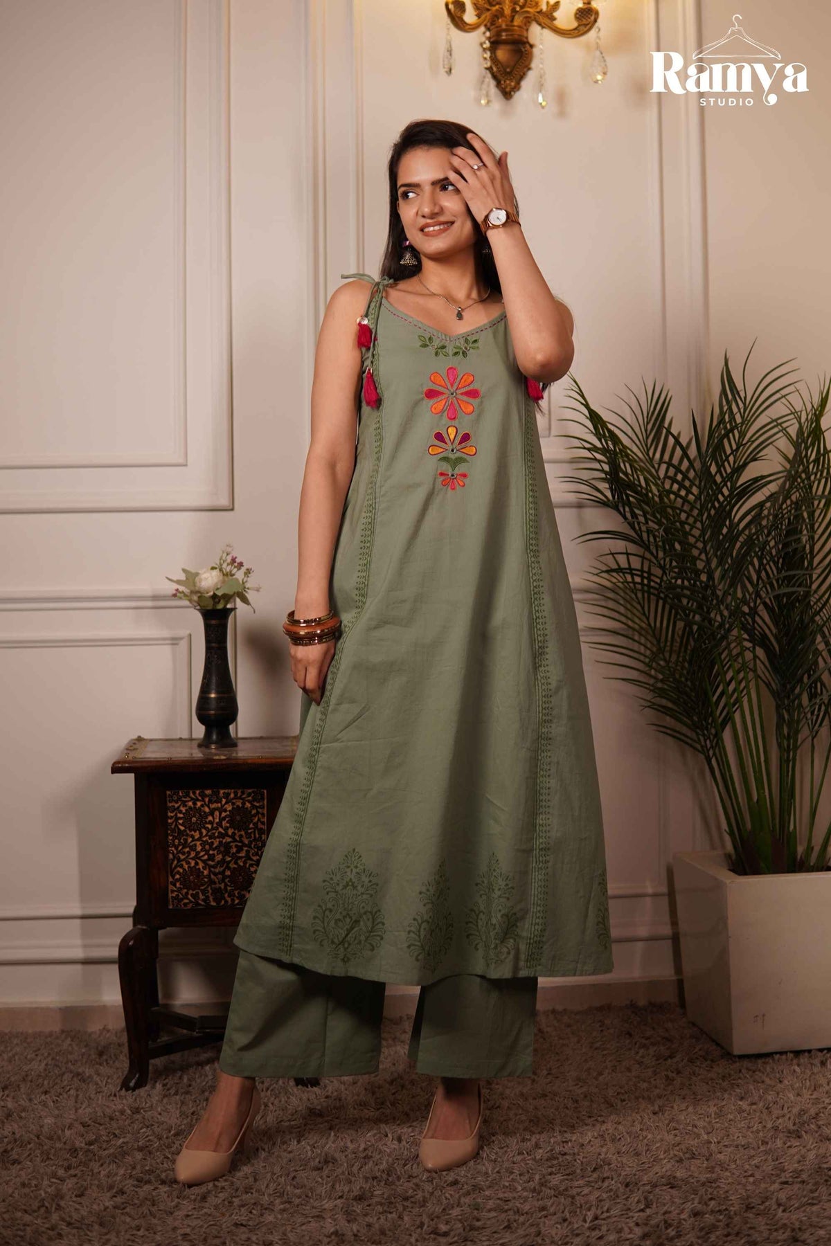 Model posing in an olive sage tie-shoulder A-line tunic paired with wide-leg pants from the Ramya Studio Gulaal-on-Green ethnic set.