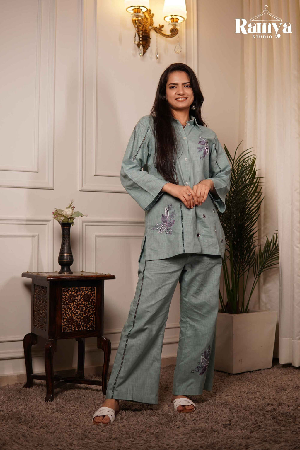 Full-length front view of a model wearing Ramya Studio's 'Pistachio Poppy' set, featuring a seafoam green cotton-linen button-down shirt and matching wide-leg trousers.