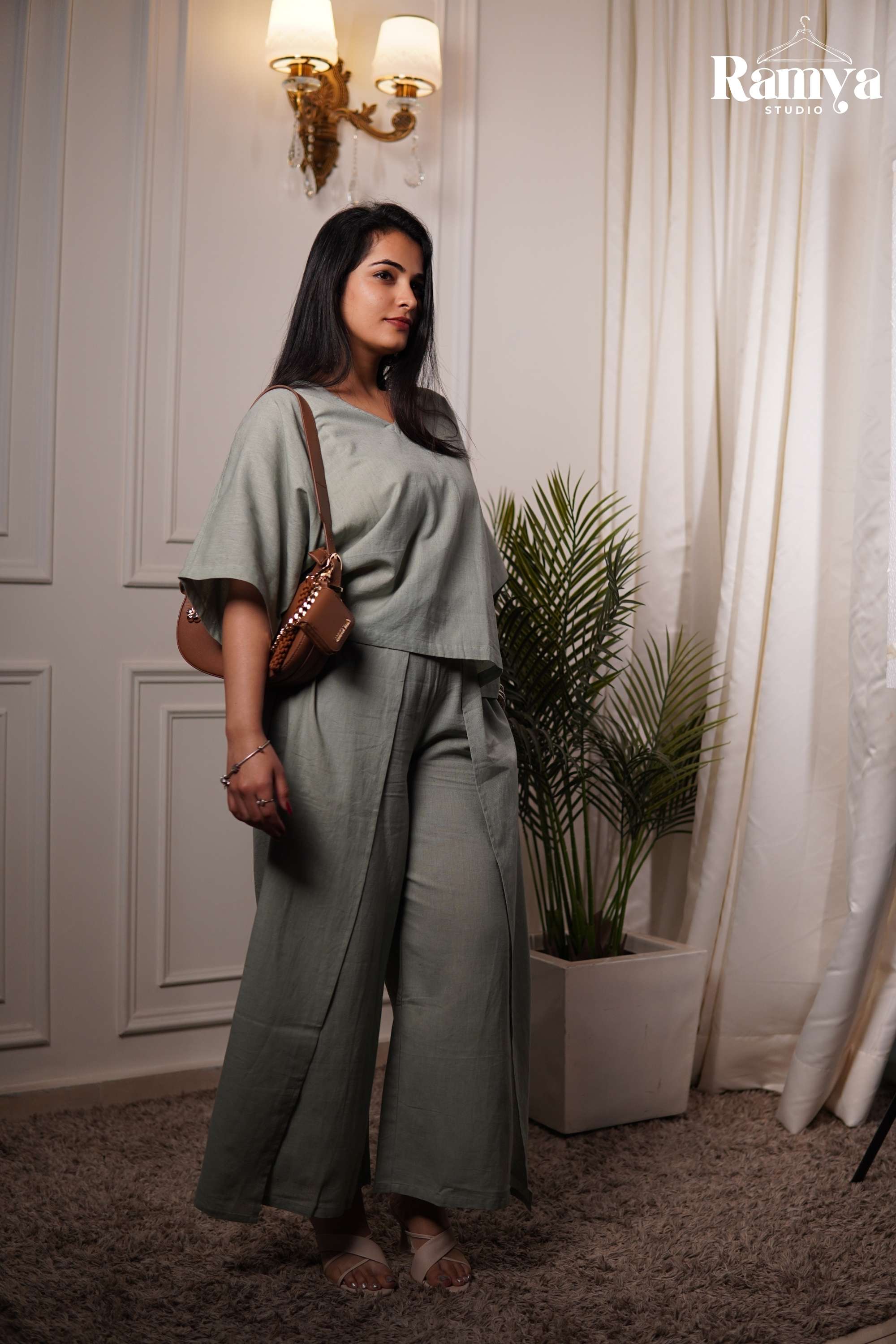 Full-length view of a women's 2-piece lounge co-ord set in solid sage green cotton-blend fabric, showcasing an oversized drop-shoulder top and flared wide-leg pants with side slits.