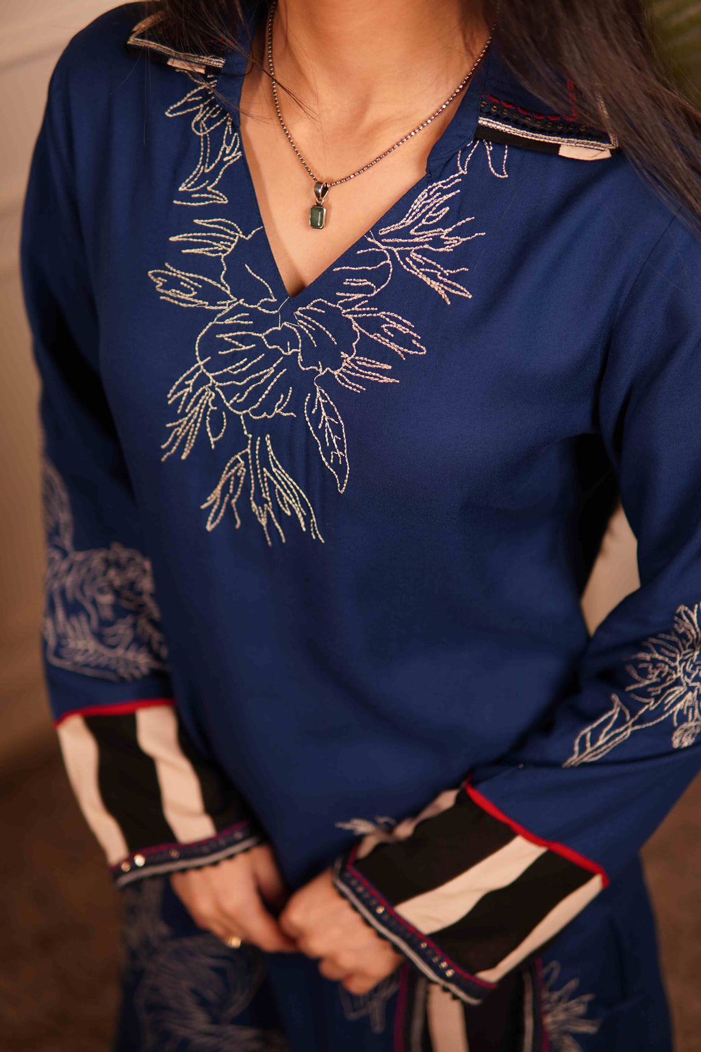 Ramya deep blue tiger motif kurta with black and white striped wide-leg trousers and transparent beaded sandals.