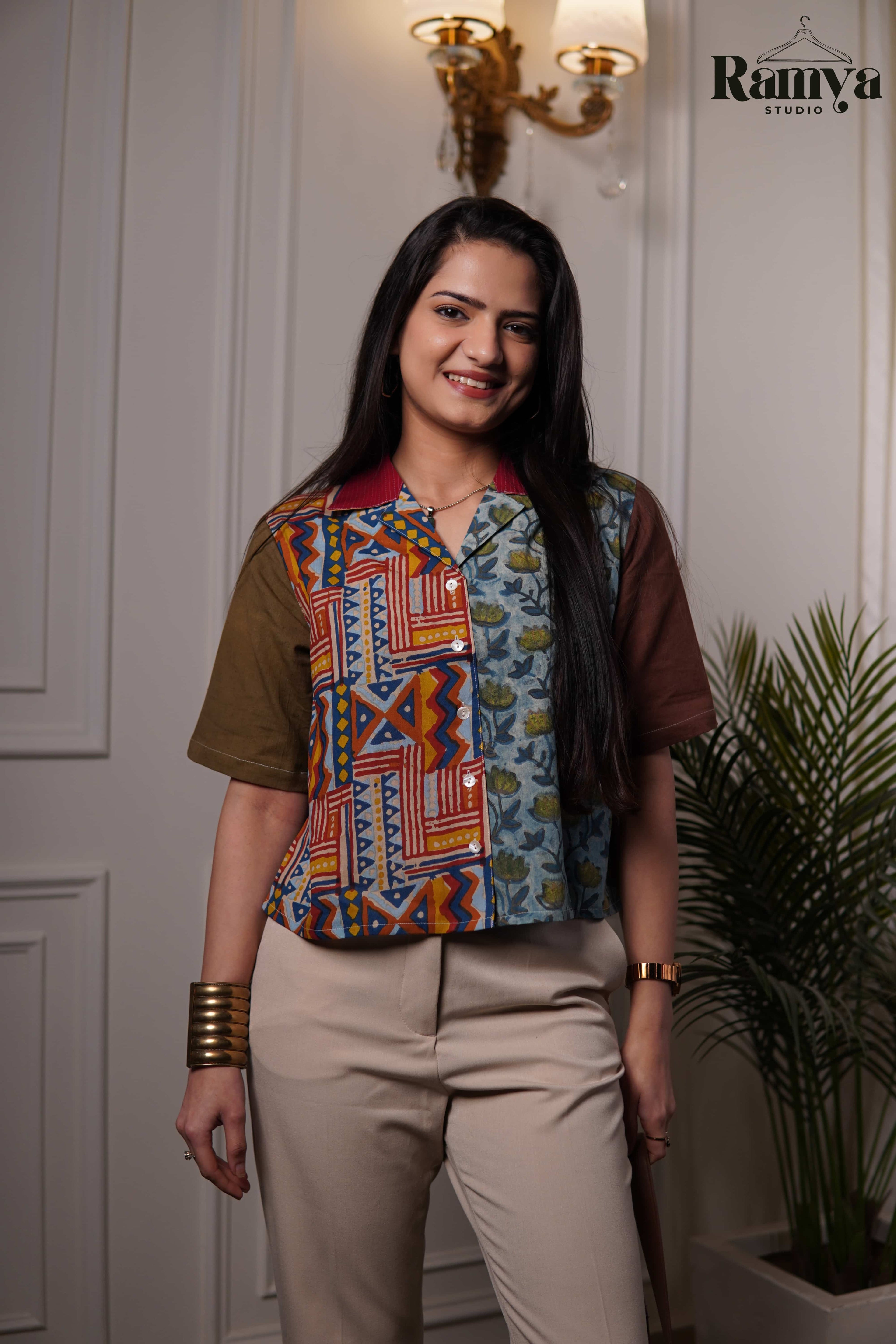 Terra Shirt Top featuring a colorful patchwork design with an olive green sleeve, a vibrant geometric red and mustard block-print panel, and a light blue floral block-print section.