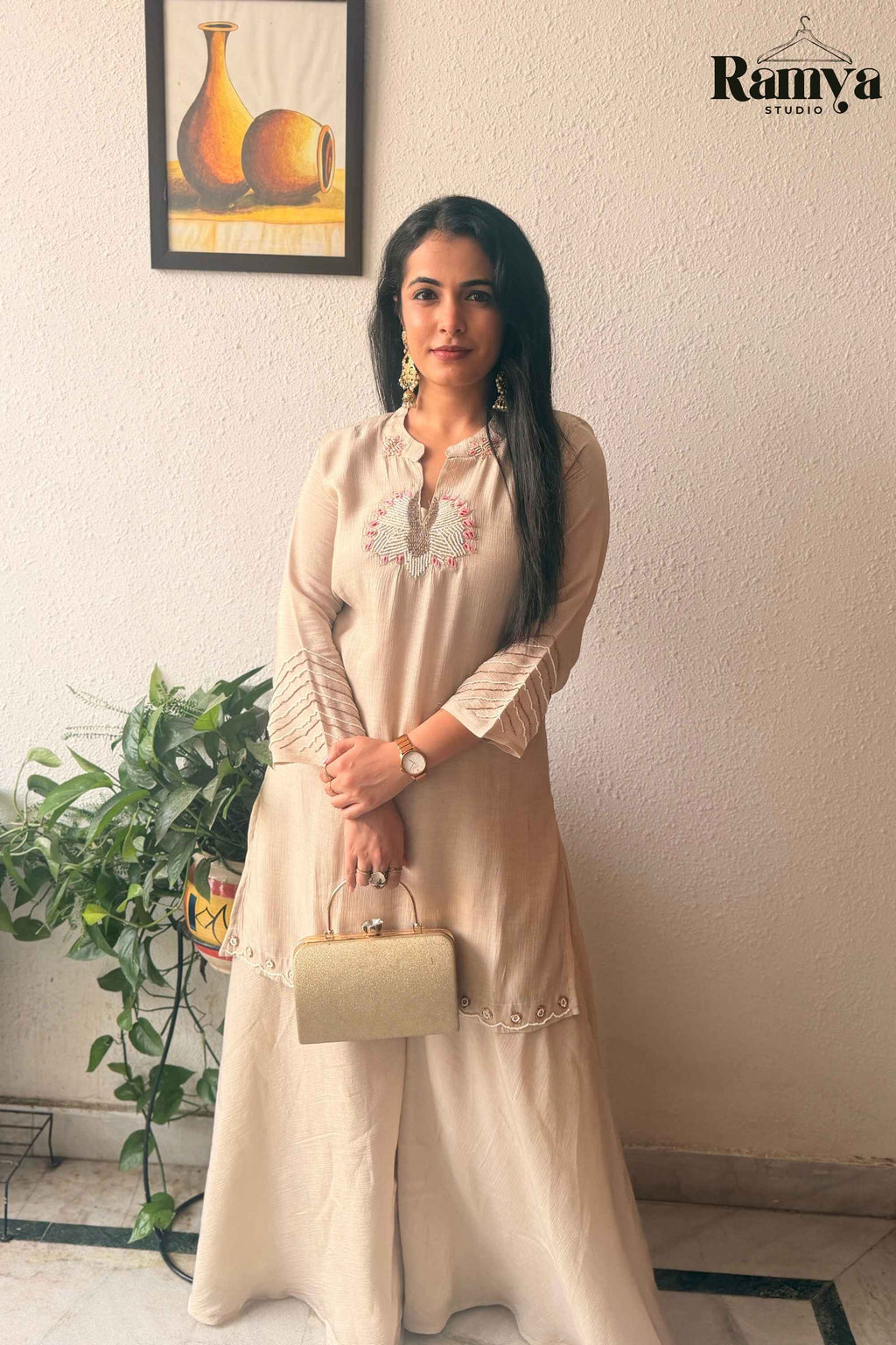 Frontal pose of a model showcasing the notched neckline with pink embroidery and pin-tuck sleeves on the Geet Ivory tunic