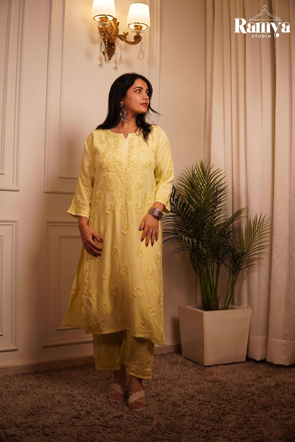 A model posing in Ramya Studio's 'Lemonade on Labels' co-ord set, featuring a pastel lemon-yellow straight kurta with intricate, tonal hand-embroidered Lucknowi Chikankari floral motifs and matching straight-cut pants.